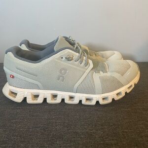Used On Cloud Running Sneakers in a Bluish/Gray and Cream Color.